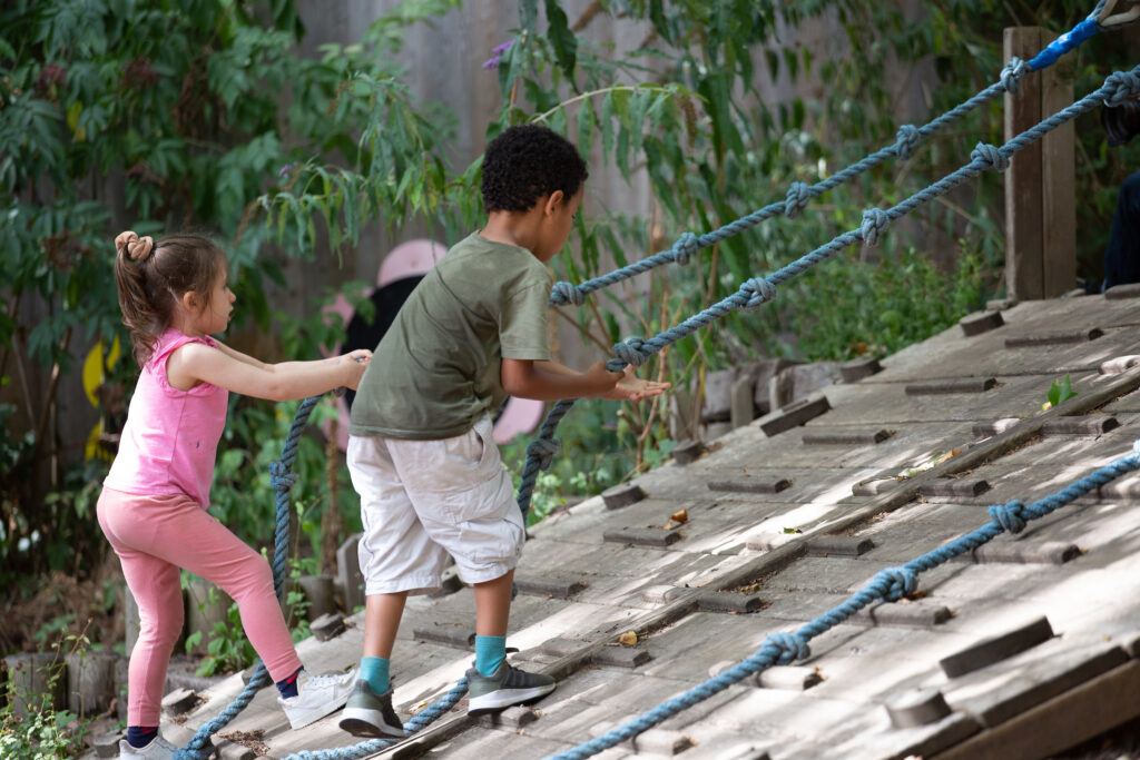 Photo of children playing, climbing ropes in an outdoor playground