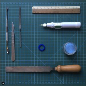 Flat lay of various wax carving tools on a cutting mat