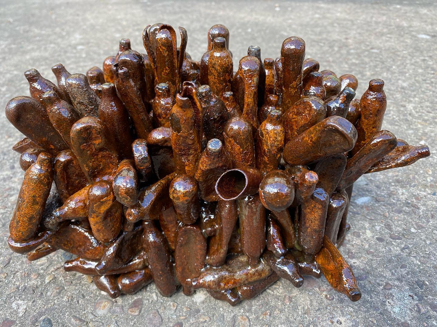 Floor based sculpture made up from rusty/discarded laughing gas canisters