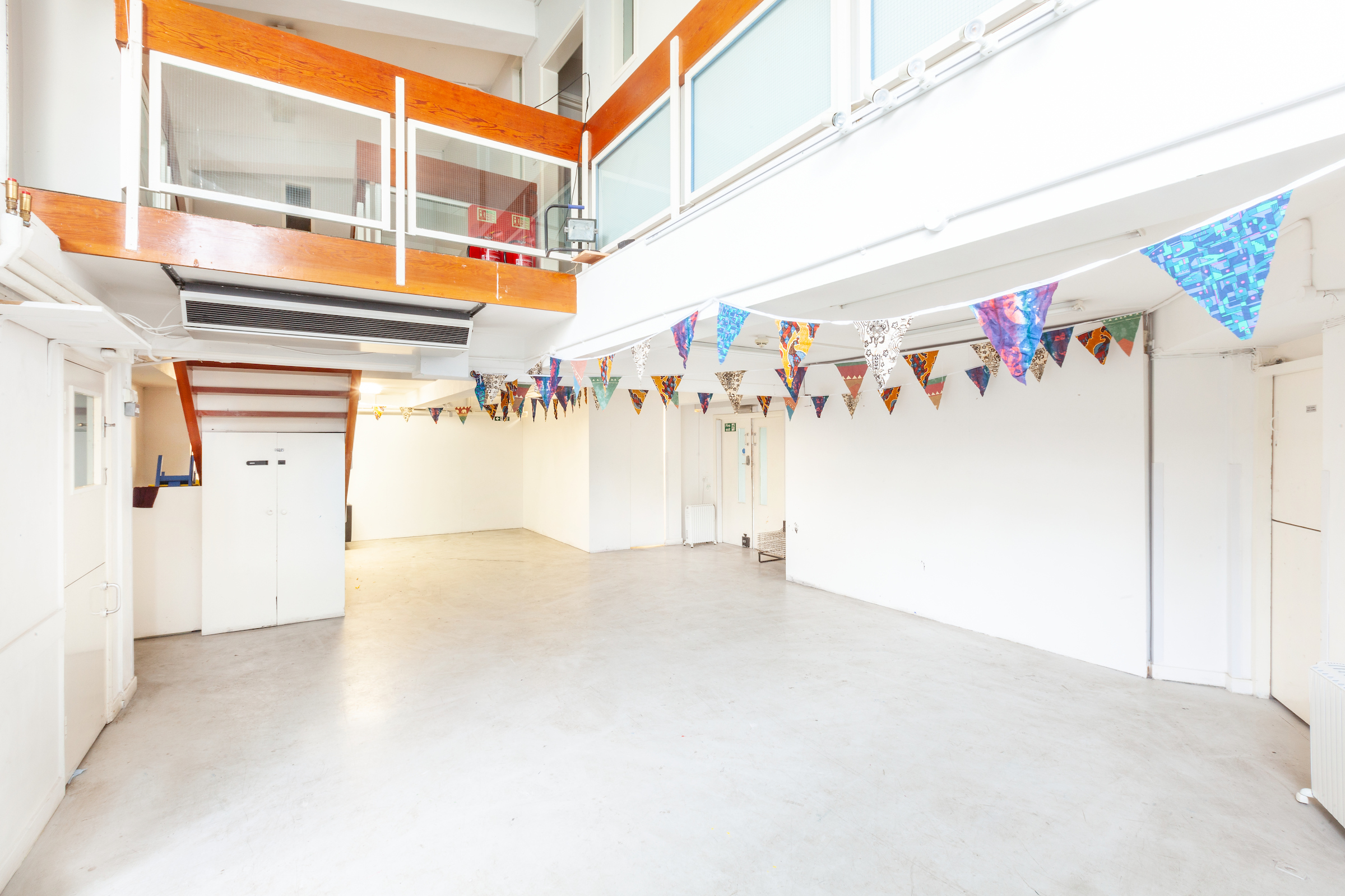 Photograph of a bright indoor space, a converted nursery, bunting hanging from the ceiling