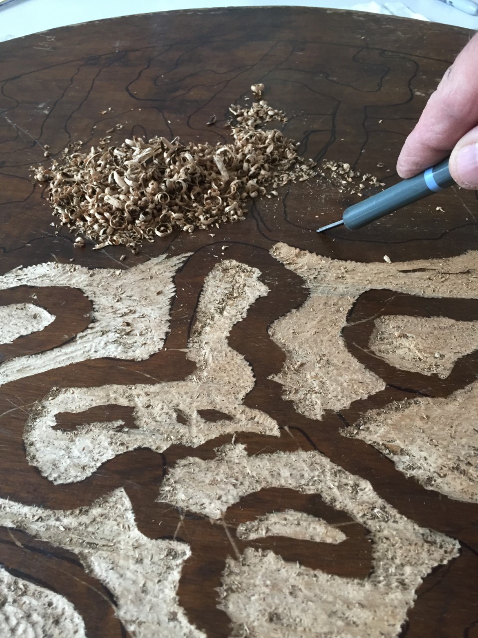 Close up of a wooden block being carved for printmaking purposes