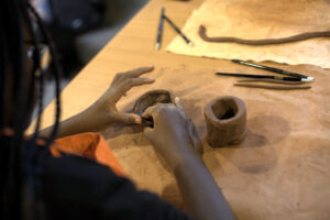 Close up photograph of a child's hands modelling clay, indoors