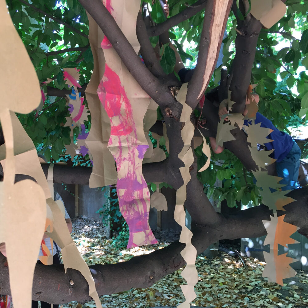 Photograph of a creative activity taking place on top of a tree, outdoors