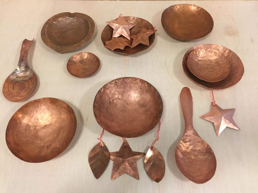 Flat lay of various hand shaped copper bowls and utensils