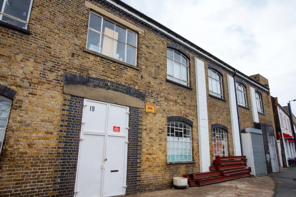 Street view of an industrial beige brick two-storey building.