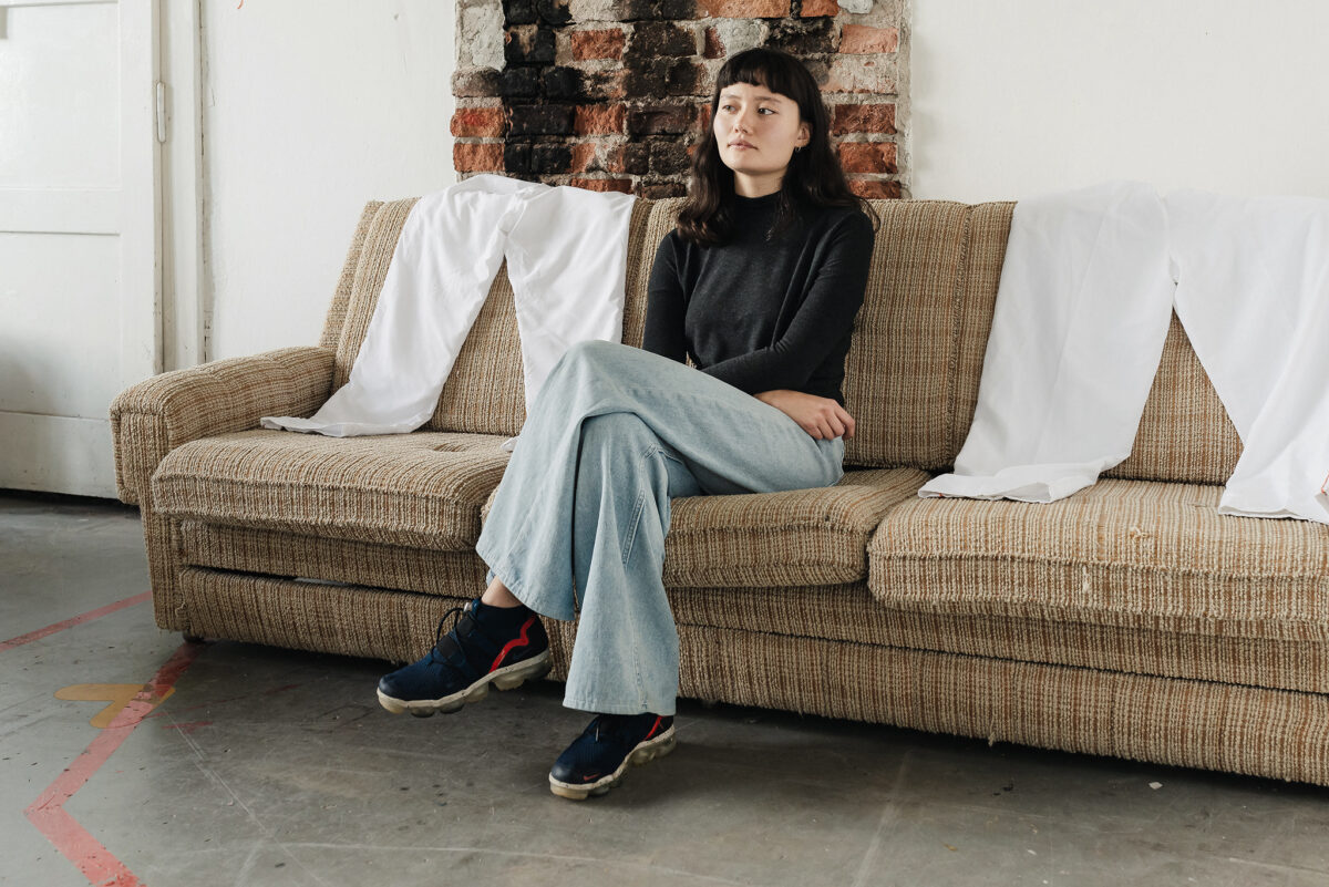Portrait of Amelia Tan sitting on a sofa, indoors.