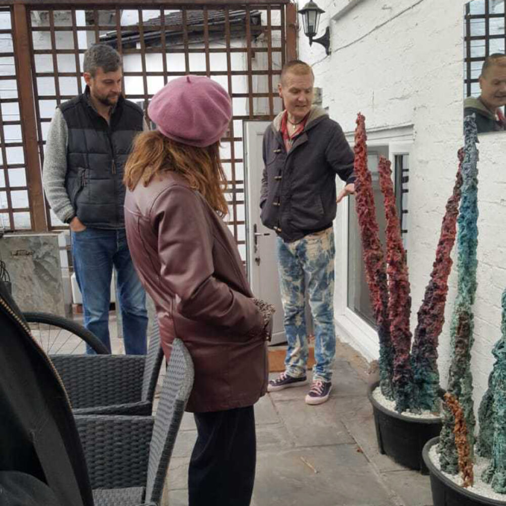 Phil showing a large pointy stalagmite-style sculpture to peers in his Stoke studio.