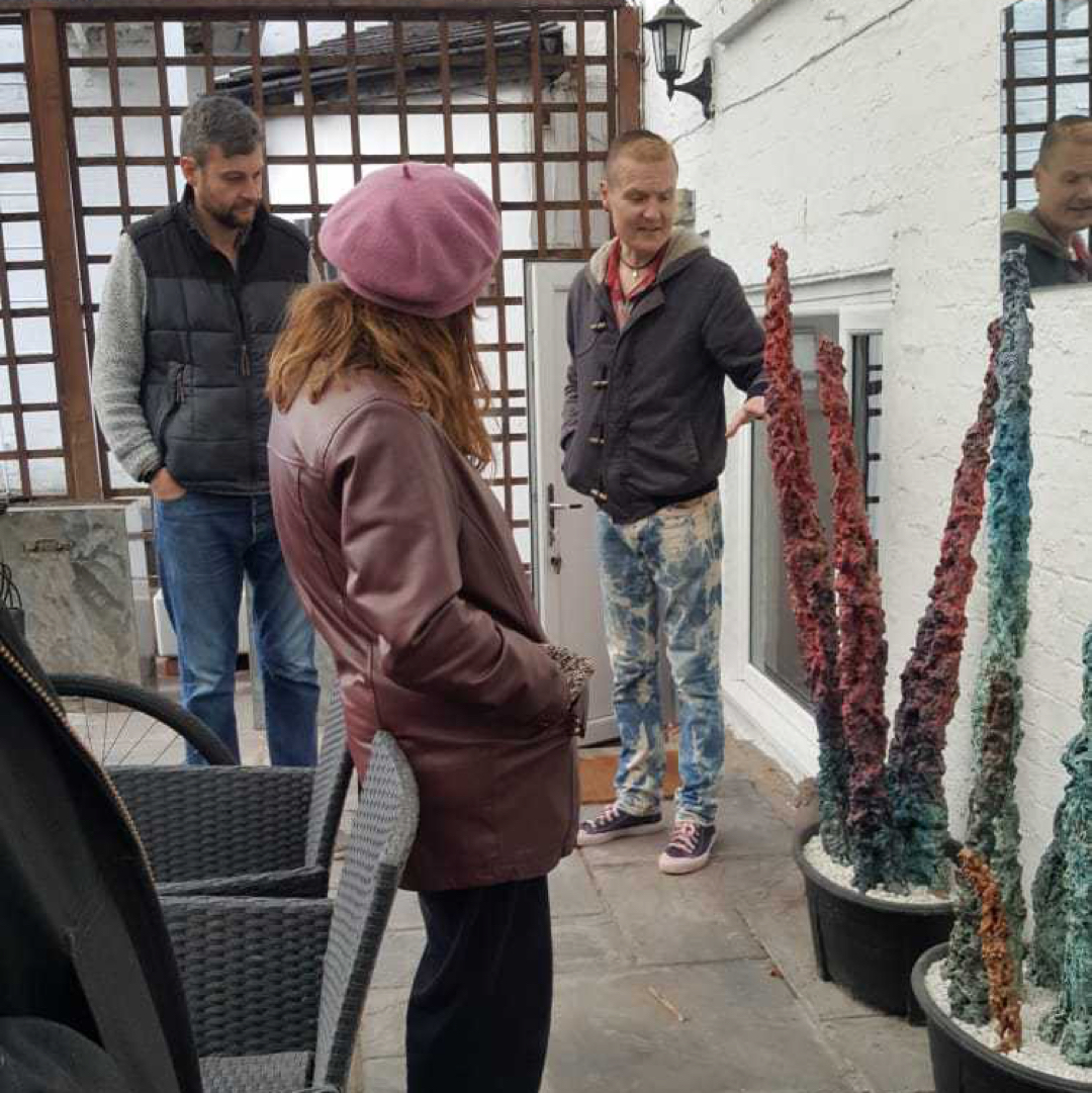 Phil showing a large pointy stalagmite-style sculpture to peers in his Stoke studio.