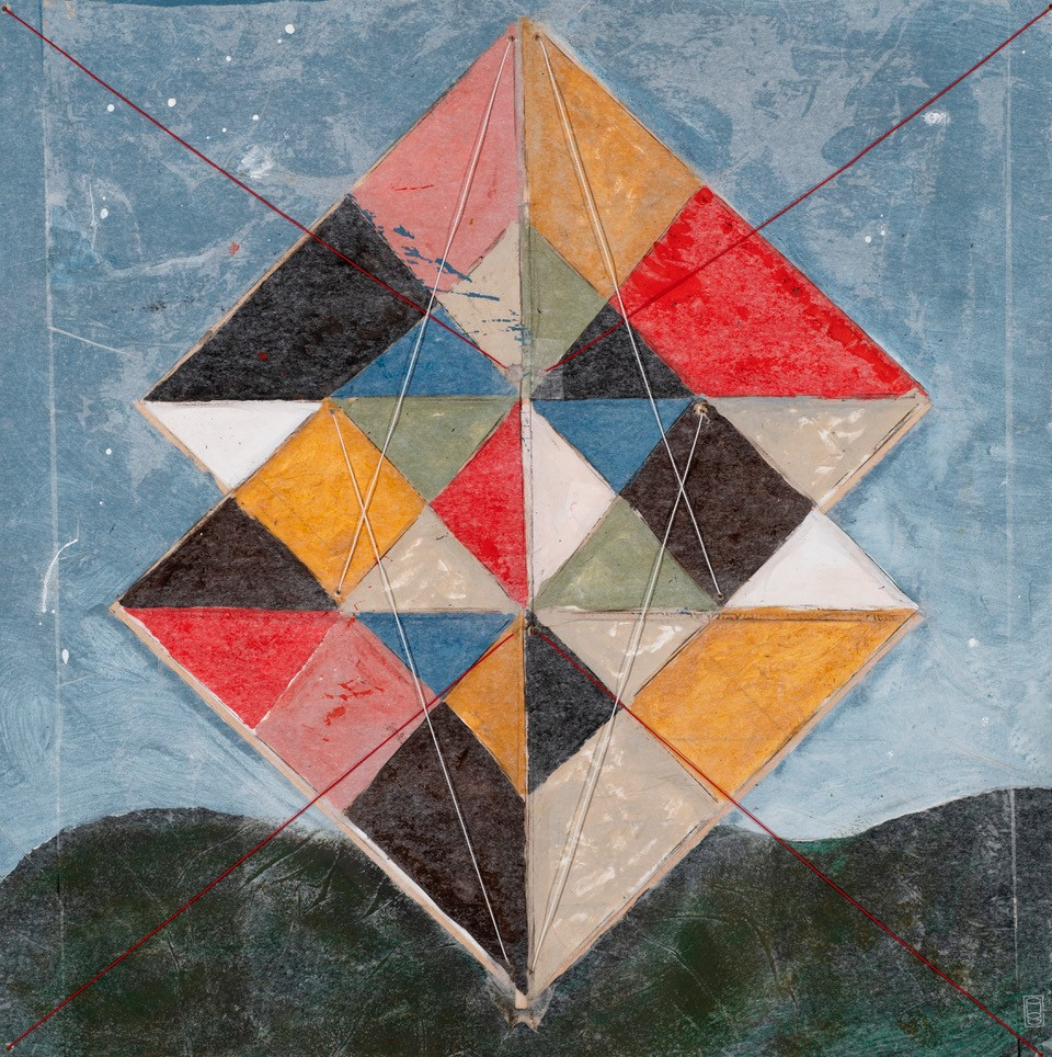 Image description: Abstract geometric painting of two upright squares in a harlequin pattern standing against a landscape, mimicking a kite.