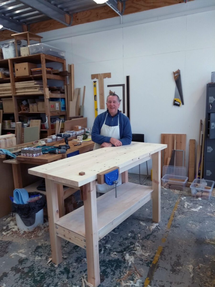 Steve Barlow posing next to one of his workbenches, in his wood carpentry studio at Spode Works Studios.