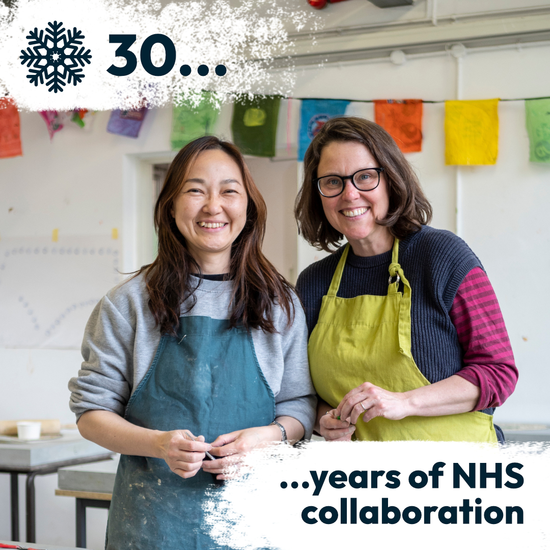 ACAVA artists Tomomi Yoshida and Emily Fuller smiling for the camera, during a Grenfell Memorial Community Mosaic session with the local community.