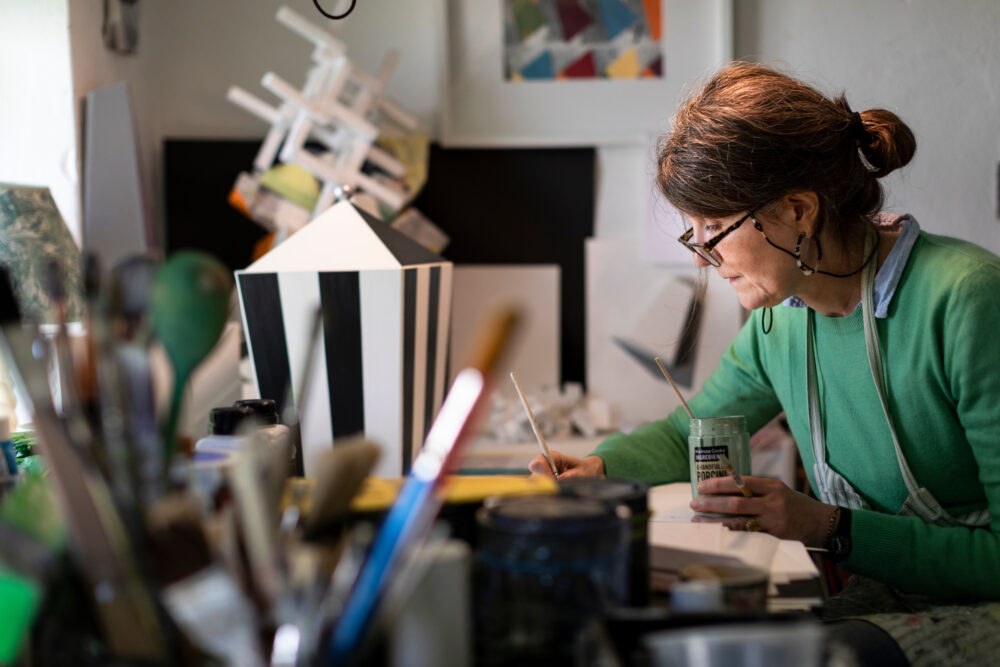 Photograph of an artist working on a table in their studio