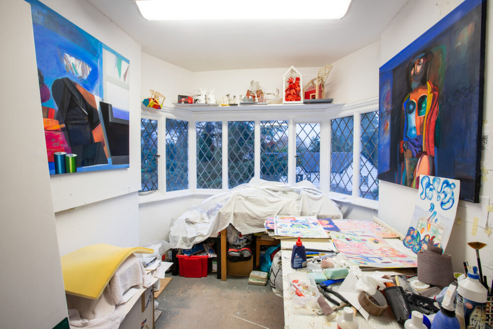 Photograph of a bright painter's studio with Tudor-style windows.